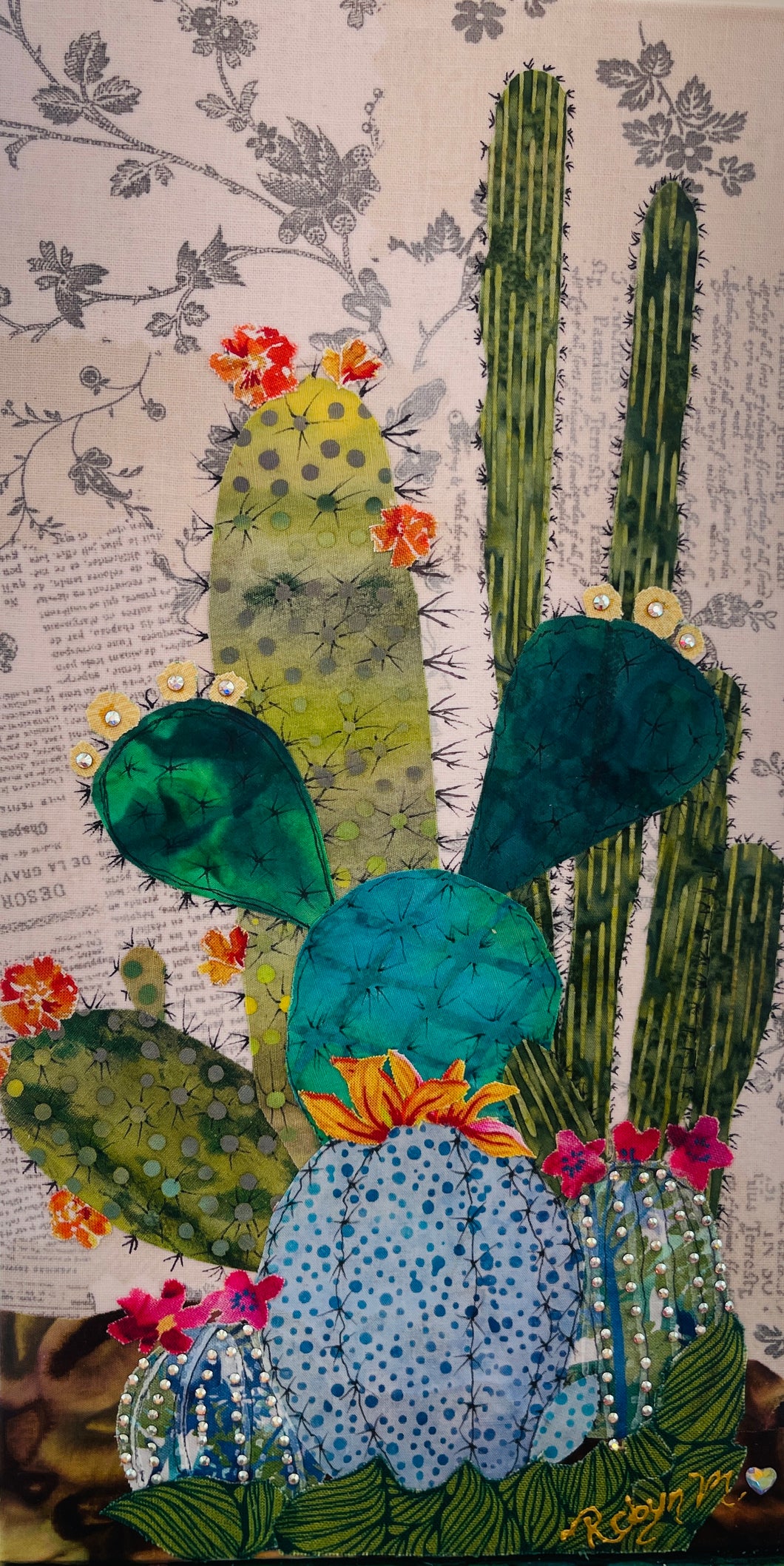 Original saguaro cactus fabric artwork 6x12 inches, tall saguaro in deep green fabric with prickly pear and pad cacti in chartreuse teal blue polka dot batik Swarovski crystal flowers scattered blooms ink pen spine detail, vintage toile botanical text background warm brown ground, birch panel, Floral Botanical Collection, Robyn Moore Arts