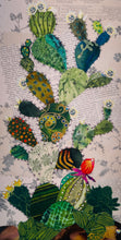 Original cactus fabric artwork 6x12 inches, prickly pear cactus in layered patterned batik fabrics teal gold olive orange with Swarovski crystal white flower centers ink pen spine detail single orange red bloom, vintage toile botanical text background warm brown ground, birch panel, Floral Botanical Collection, Robyn Moore Arts