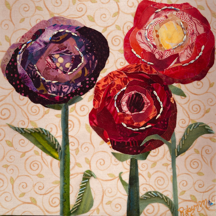 Fabric flower artwork with three layered blooms in red, coral, and purple tones  and Swarovski crystals on 8x8 panel with patterned background
