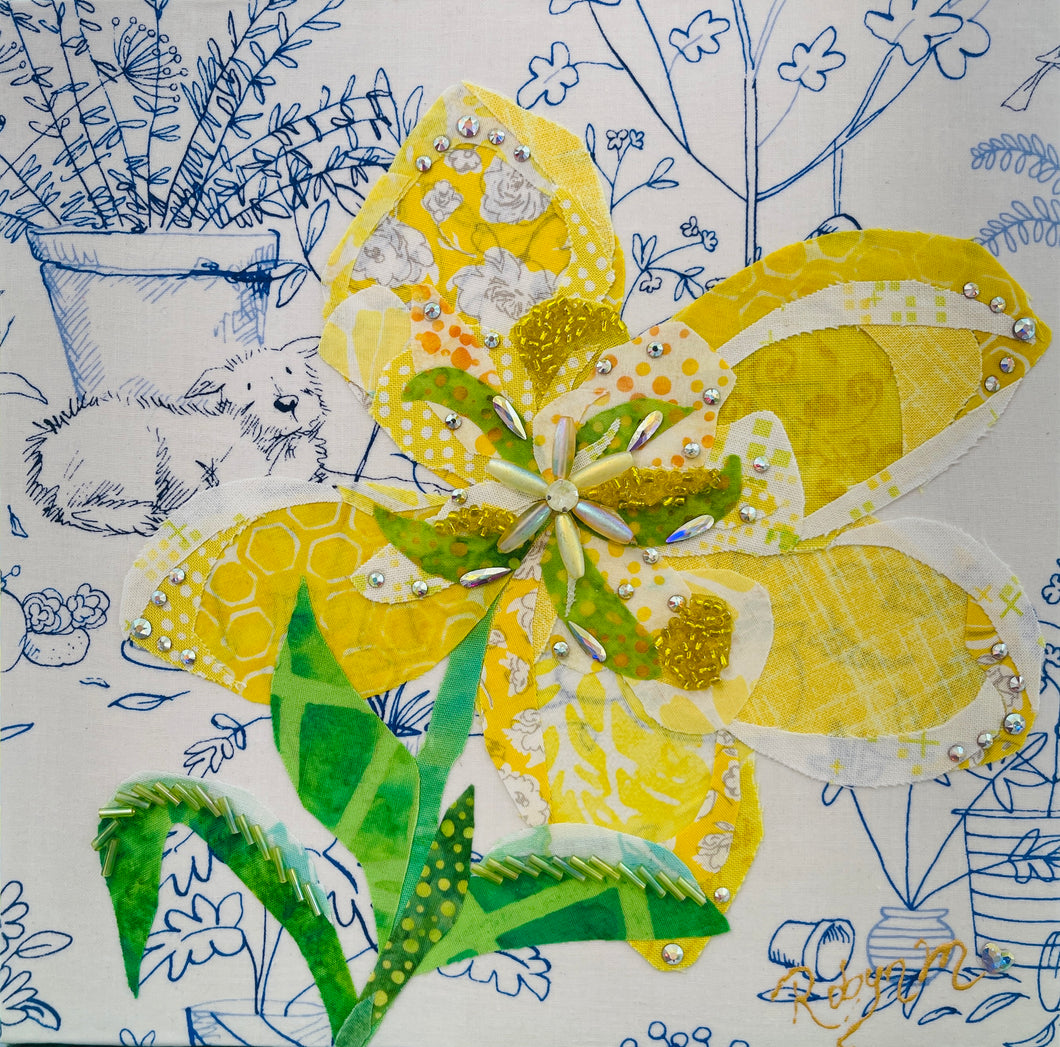 Yellow fabric flower artwork on 8x8 panel with layered textiles, Swarovski crystals, beads and green leaves on illustrated botanical background