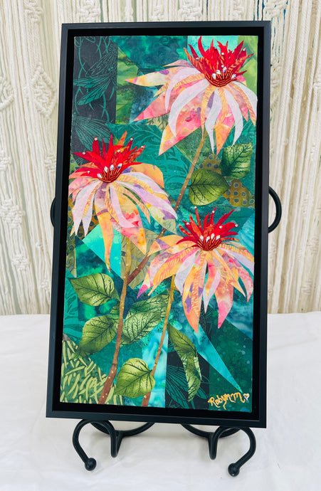 Original vertical botanical fabric art 16x8 inches, three cone flower blooms in blush pink peach orange and crimson batik fabric rising on slender stems, Czech glass bead and Swaraovski crystal embellished centers, deep forest green and teal batik background with leaf forms, on birch panel, part of the Floral and Botanical Collection by Robyn Moore Arts