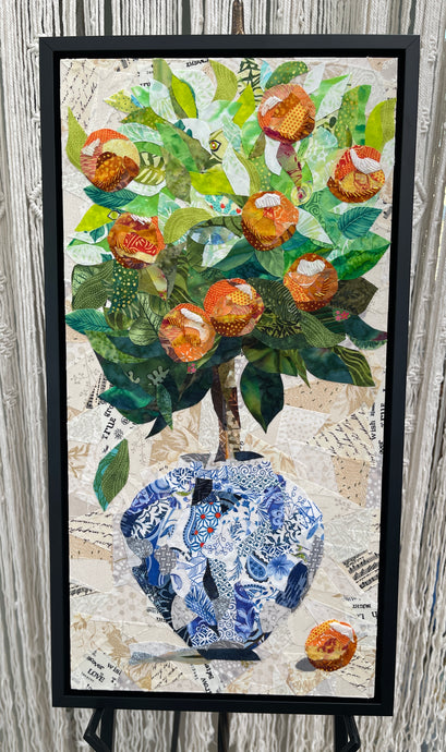 Original mixed media botanical artwork 12x24 inches, lush bouquet of peach and orange fabric blooms in a patchwork blue and white chinoiserie fabric vase, layered green foliage, vintage paper ephemera background with handwritten text and sheet music, Czech glass bead detail, on birch panel, part of the Floral and Botanical Collection by Robyn Moore Arts