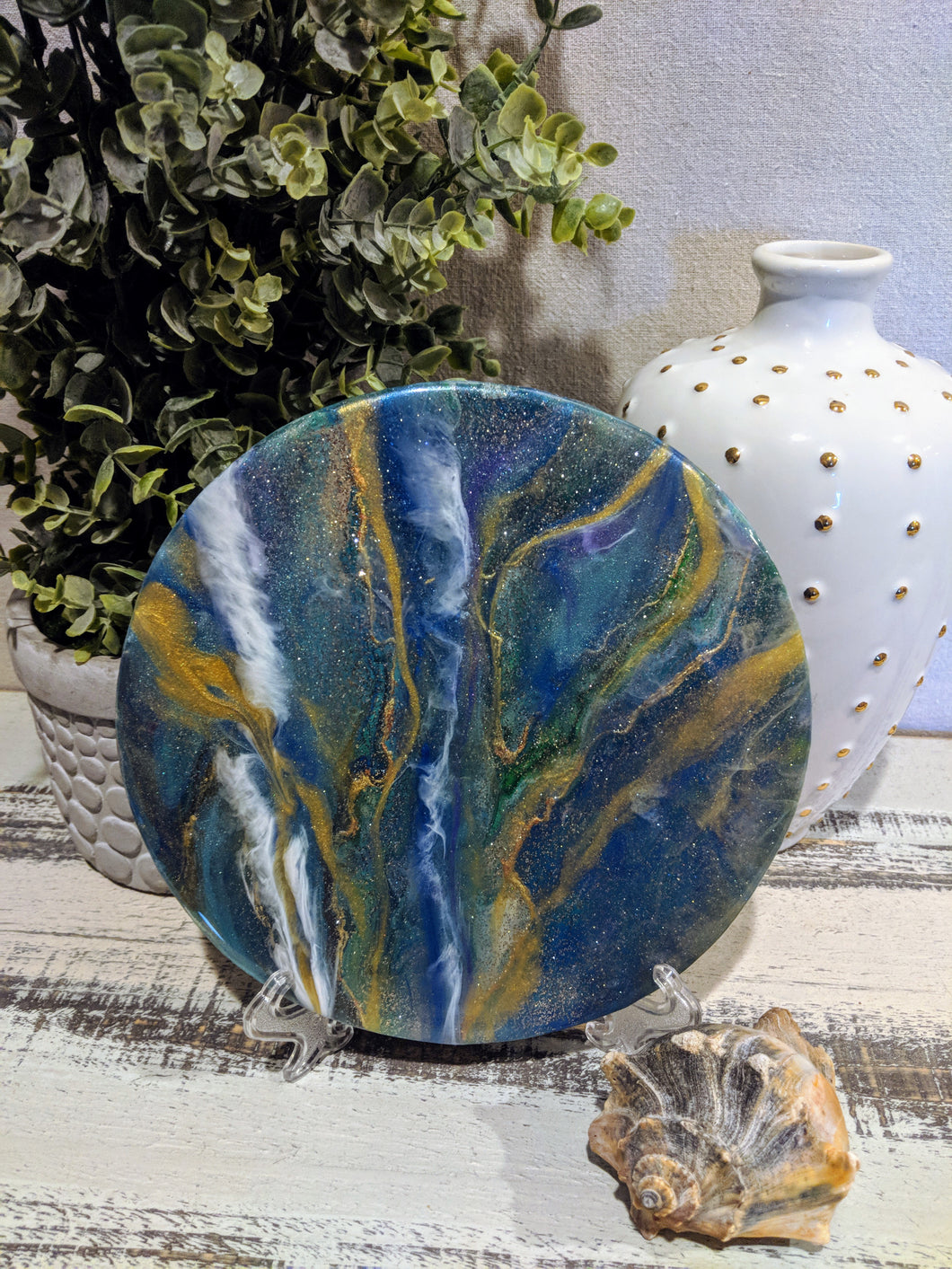 abstract fluid acrylic round painting with texture and vibrant blue colors and glitter