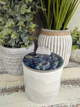 white and grey canister with blue lid and crystal stone
