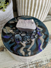 white and grey canister with blue lid and crystal stone