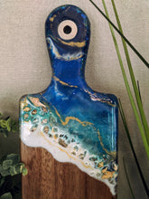 close up abstract ocean resin cheese board with shells and fire glass