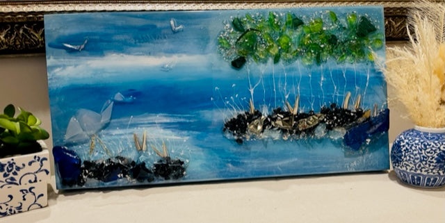“Small coastal artwork made with recycled glass and resin, featuring soft blue tones and light-reflective texture”