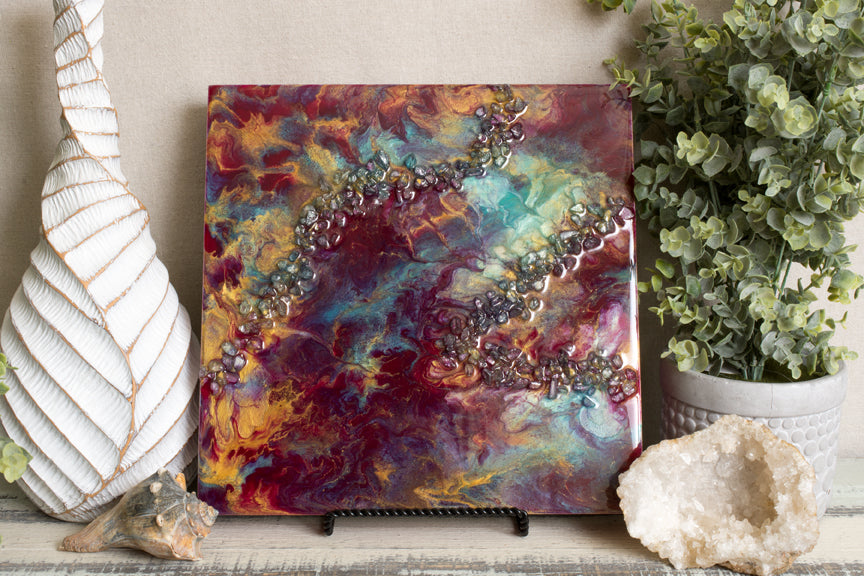 abstract crimson and teal fluid resin art with stones