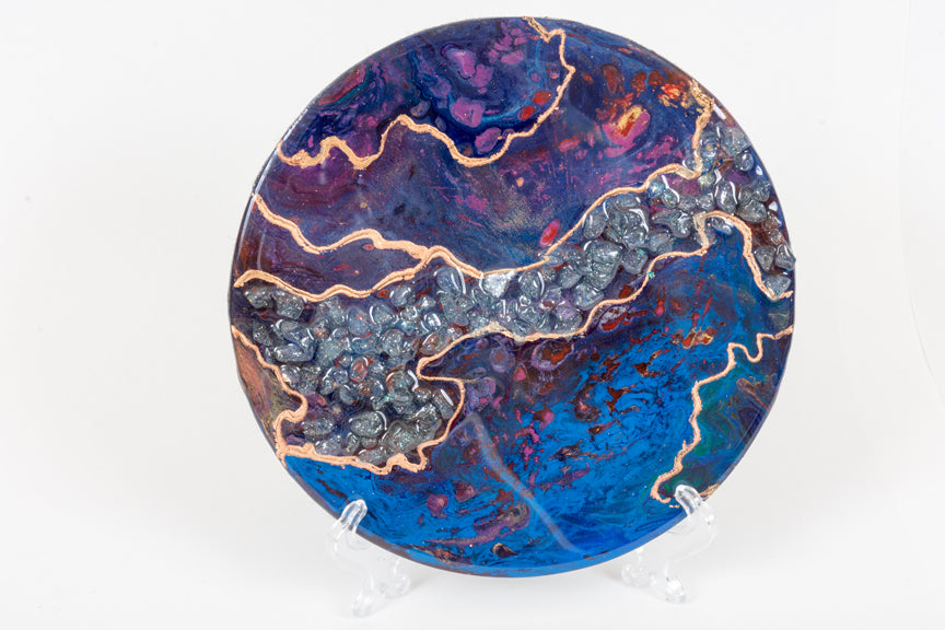abstract fluid acrylic resin painting with vibrant blue deep magenta and gold colors with stones